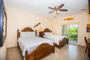 two beds in a room with a ceiling fan at Lawson Rock - Angelfish 202 Condo in Sandy Bay +28 photos