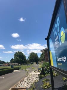 a sign for a car dealership on the side of a road at Cambridge Top 10 Holiday Park in Cambridge