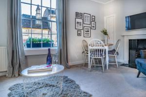 a living room with a table and chairs and a fireplace at The Apartment, Bath in Bath