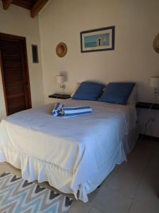 a white bed with blue pillows and a surfboard on it at Simpson Bay Yatch Club 2 Bedrooms in Simpson Bay