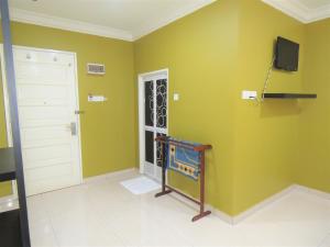 a room with green walls and a door and a television at Gm Motel in Kuah