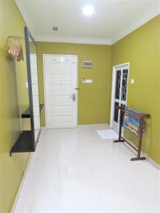 um quarto com paredes verdes e piso em azulejo branco em Gm Motel em Kuah