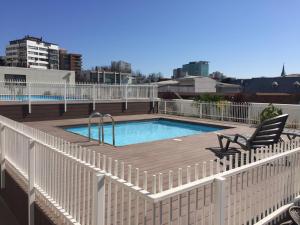 a swimming pool with a wooden deck and a chair at Viña del Mar - Parque Marina in Viña del Mar