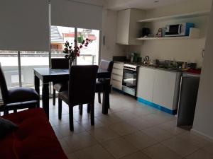 eine Küche mit einem Tisch und Stühlen sowie eine Küche mit einer Theke in der Unterkunft Potosí 3831 (Almagro Norte) in Buenos Aires