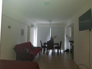 ein Wohnzimmer mit einem Tisch und einem roten Sofa in der Unterkunft Potosí 3831 (Almagro Norte) in Buenos Aires
