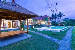 a villa with a swimming pool and a resort at Champaca Villas Ubud in Ubud
