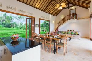 乌布Champaca Luxury Villas Ubud的有一张大桌子和几把椅子的餐厅