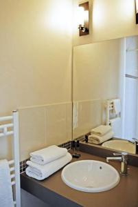 a bathroom with a sink and a mirror at Hôtel Ronsard in Tours