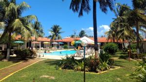 a resort with a swimming pool and palm trees at Hotel Praia do Conde in Conde