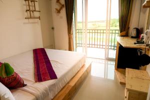 Un pat sau paturi într-o cameră la Baan URT Suratthani Airport Hotel