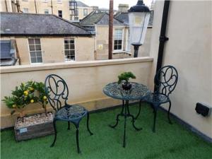 um pátio com 2 cadeiras e uma mesa na varanda em Chapel Lodge - Roof top garden!Perfect for your family em Bath