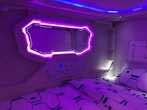 een kamer met een tv en een bed met paarse verlichting bij Dormitos in Manilla