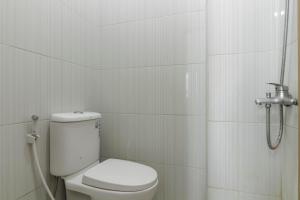 uma casa de banho branca com um WC e um chuveiro em RedDoorz near Central Park Mall em Jakarta