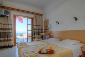 a hotel room with a bed with a tray of food on it at Adonis Hotel in Agia Galini