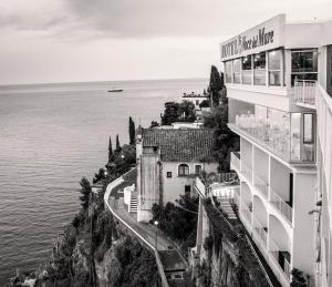 a black and white photo of a building next to the water at Hotel Voce del Mare in Vietri sul Mare