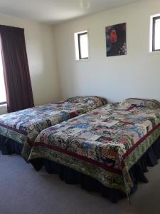 a bed in a bedroom with a quilt on it at 201Waimumu in Gore