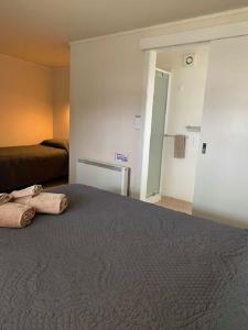 懷烏魯的住宿－Waiouru Welcome Inn，一间卧室配有一张床,上面有两条毛巾