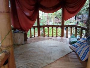 a wooden porch with a bed on a deck at NewAlasKuliner & HomestayWatulumbung in Yogyakarta