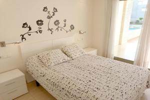 a bedroom with a bed with a white comforter at Tierra de Mar 10 in Denia