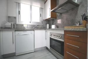 デニアにあるElegance 55の白いキャビネットと食器洗い機付きのキッチンが備わります。