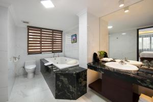 a bathroom with a tub and a sink and a toilet at Halais Hotel in Hanoi