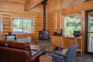 a log cabin living room with a wood stove at Log Inn Bonners Ferry in Bonners Ferry