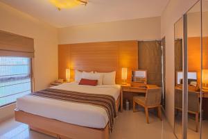 um quarto com uma cama, uma secretária e uma televisão em Oakwood Residence Naylor Road Pune em Pune