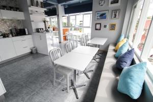 una cucina e una sala da pranzo con tavoli bianchi e cuscini blu di The Moon Hostel Huahin a Hua Hin