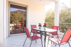 a dining room with a table and chairs on a balcony at Our House Luxury Suites in Paleo Tsifliki