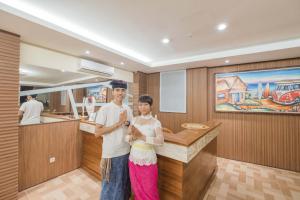 a man and a woman standing in a kitchen at Caroline Guest House in Canggu +49 photos