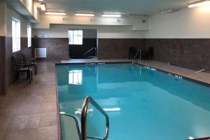 a large swimming pool with blue water in a room at Comfort Inn Early Brownwood in Early
