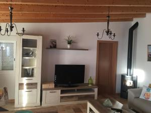 sala de estar con mesa y TV en La Era Casa Rural en La Cisnera