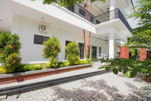 un edificio blanco con un patio con plantas en RedDoorz Premium @ Setiabudi Medan en Sunggal