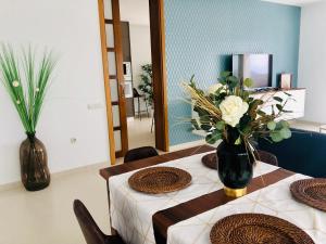 una sala da pranzo con due tavoli e un vaso di fiori di Canaryislandshost l Infinity Views a Nazaret