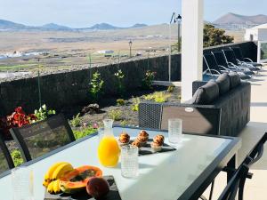 een tafel met fruit en sap op een balkon met uitzicht bij Canaryislandshost l Infinity Views in Nazaret