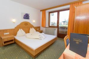 1 dormitorio con cama y ventana en Hotel Neuwirt, en Kirchdorf in Tirol
