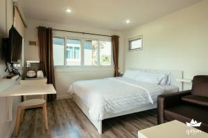 黎府的住宿－Phu Sumphao Valley ภูสำเภา วัลเลย์ รีสอร์ต，卧室配有白色的床和沙发