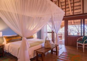 a bedroom with a bed with white mosquito netting at Cabo Beach Villas in Santa Maria