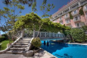 a hotel with a bridge over a swimming pool at Grande Albergo Marin in Lignano Sabbiadoro