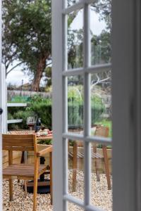 A Cottage In Richmond في ريتشموند: اطلالة على طاولة وكراسي من خلال النافذة