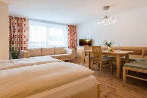 a hotel room with a bed and a dining room at smartFLATS in Dorfgastein