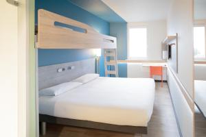 a bedroom with a bunk bed and a desk at ibis budget Genève Aéroport in Geneva