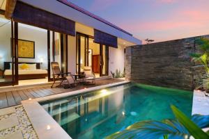 a villa with a swimming pool and a bedroom at Sudha Villa Bali Baik-Baik in Seminyak