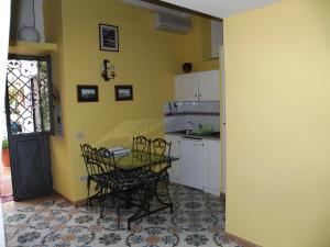 a kitchen with a table and chairs in a room at La Dolce Meta in Meta