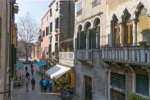 a group of people walking down a street next to buildings at La Perla del Doge con Wellness & Spa uso esclusivo - La Perla Apartments in Venice