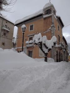 ヴィッレッタ・バッレーアにあるHotel Il Vecchio Pescatoreの時計塔のある建物前の積雪