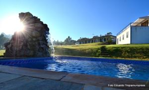 a water fountain with the sun shining behind it at Pouso do Alferes in Santo Antônio do Leite