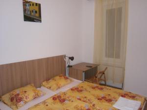 a bedroom with two beds and a table and a chair at Fanni Budapest Guesthouse in Budapest