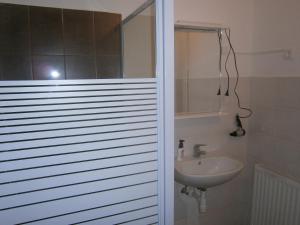 a bathroom with a sink and a white wall at Fanni Budapest Guesthouse in Budapest