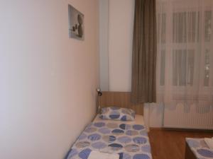 a small bedroom with a bed and a window at Fanni Budapest Guesthouse in Budapest